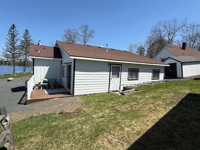 CABIN5 Gruenhagen Rd, Long Lake Twp, WI 54817 - back of house with a deck with water view, a lawn, an outbuilding, a shed, and a shingled roof
