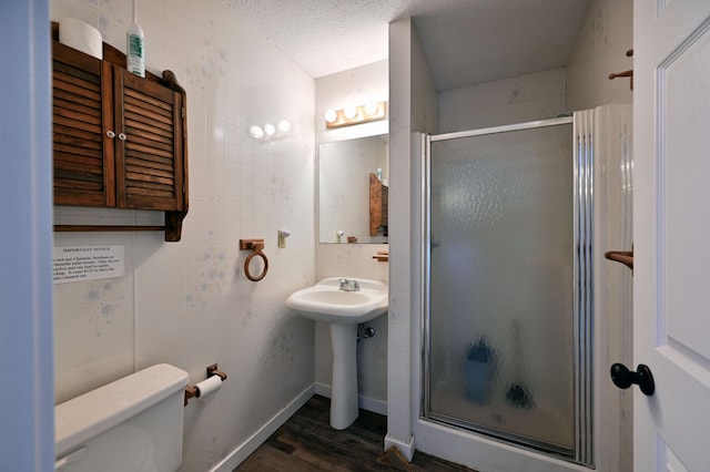 CABIN5 Gruenhagen Rd, Long Lake Twp, WI 54817 - bathroom with a stall shower, wood finished floors, a textured ceiling, and toilet