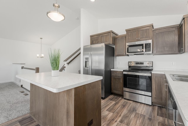 1129 Tiger Ct NE, Isanti, MN 55040 - kitchen with appliances with stainless steel finishes, lofted ceiling, light countertops, decorative light fixtures, and dark wood-style floors
