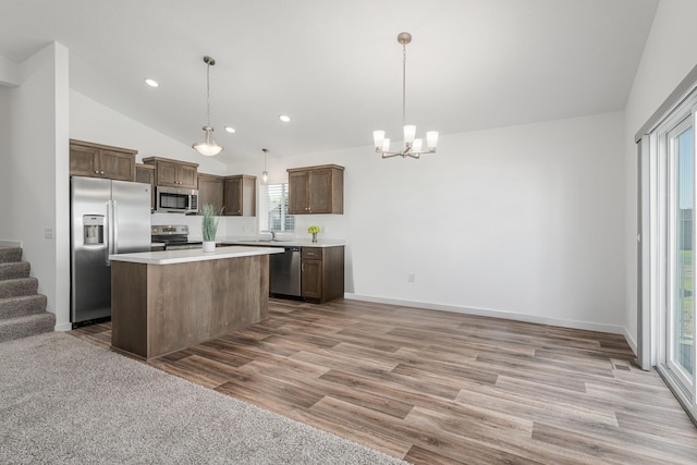1129 Tiger Ct NE, Isanti, MN 55040 - kitchen with appliances with stainless steel finishes, lofted ceiling, a chandelier, light countertops, and open floor plan