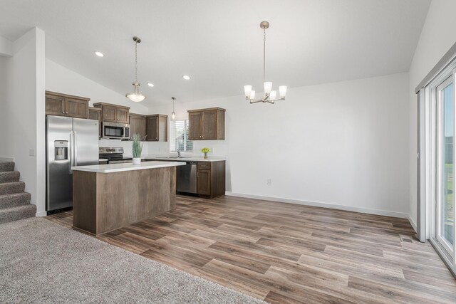 1129 Tiger Ct NE, Isanti, MN 55040 - kitchen with stainless steel appliances, a chandelier, light countertops, vaulted ceiling, and light wood-style flooring