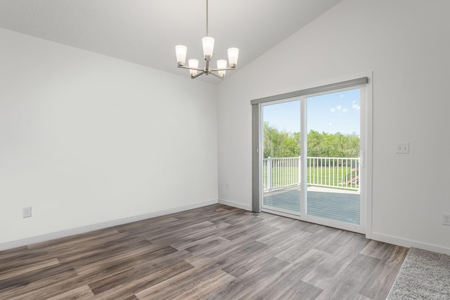 1129 Tiger Ct NE, Isanti, MN 55040 - spare room featuring a chandelier, wood finished floors, baseboards, and high vaulted ceiling