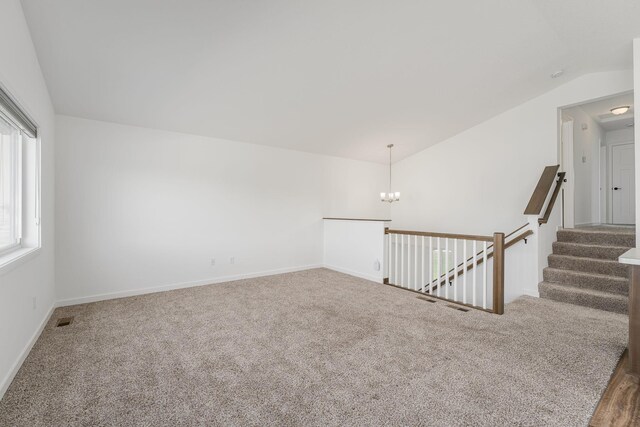 1129 Tiger Ct NE, Isanti, MN 55040 - carpeted empty room featuring vaulted ceiling, a chandelier, and baseboards