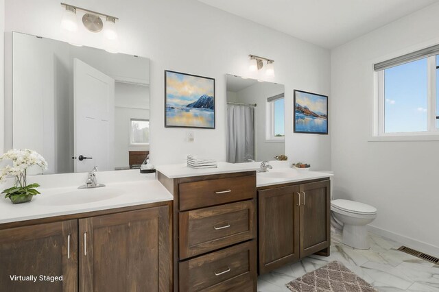 1129 Tiger Ct NE, Isanti, MN 55040 - full bathroom with vanity, plenty of natural light, marble look tiles, and toilet