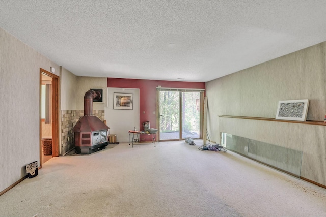 1567 Bavarian Pass, Fridley, MN 55432 - unfurnished room with a textured ceiling, carpet flooring, a wood stove, and wallpapered walls
