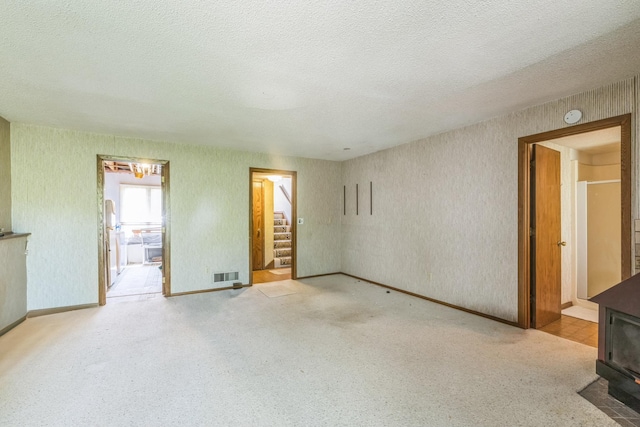 1567 Bavarian Pass, Fridley, MN 55432 - unfurnished living room with a wood stove, a textured ceiling, light carpet, and baseboards