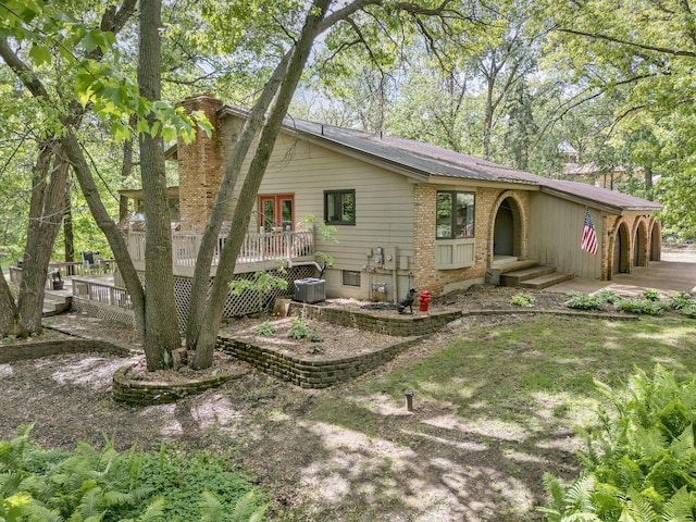 13640 Alamo St NE, Ham Lake, MN 55304 - back of property with a chimney, a wooden deck, central air condition unit, and a garage