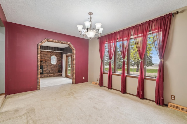 22800 401st Ave, Arlington Twp, MN 55307 - carpeted spare room with a chandelier, a textured ceiling, arched walkways, and brick wall