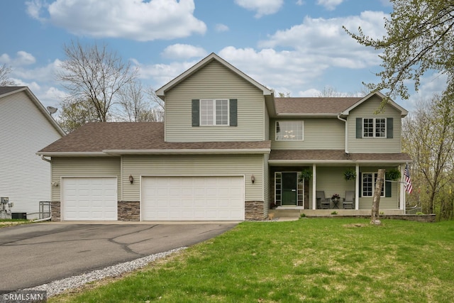 traditional-style house featuring covered porch, driveway, a front lawn, and a shingled roof