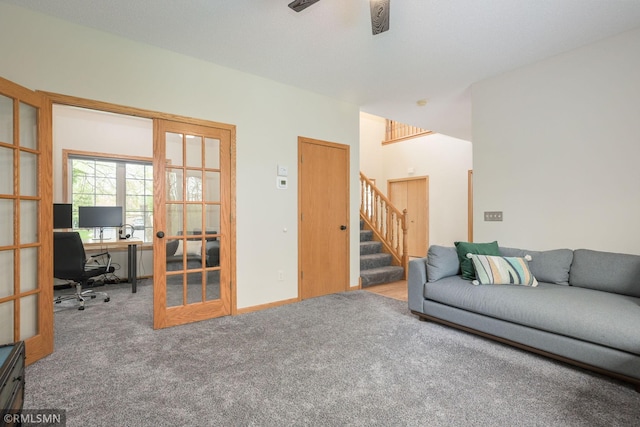 carpeted living room featuring a desk, stairs, and a ceiling fan