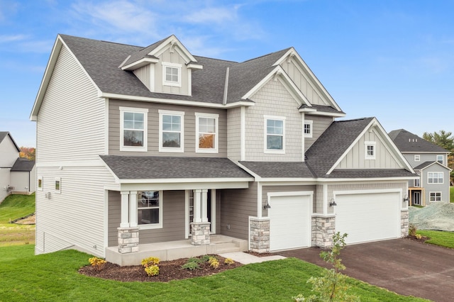 craftsman-style home featuring a porch, board and batten siding, asphalt driveway, a shingled roof, and a front yard