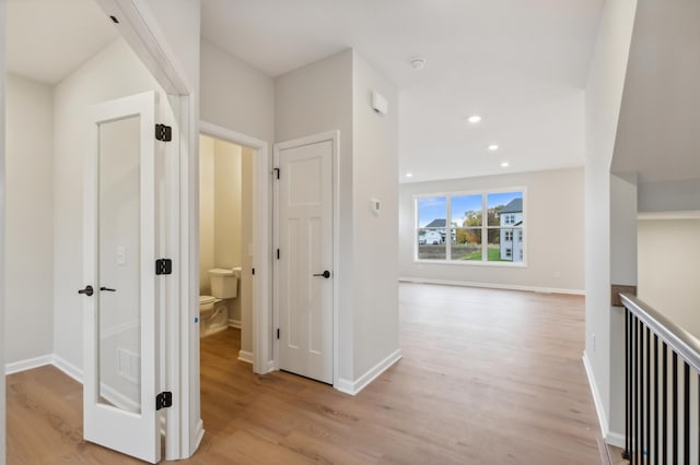 hall with light wood-style flooring, baseboards, and recessed lighting