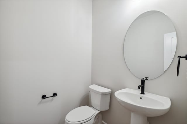 half bathroom featuring a sink and toilet