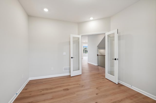 spare room featuring french doors, light wood-style flooring, baseboards, and recessed lighting