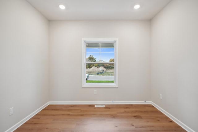 unfurnished room with light wood-type flooring, recessed lighting, and baseboards