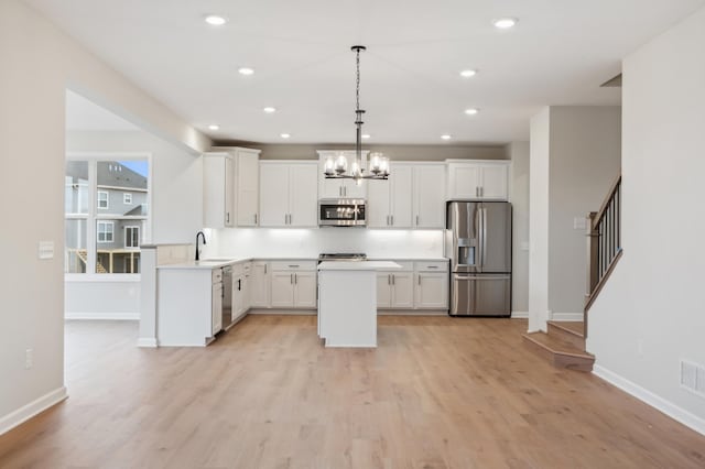 kitchen featuring appliances with stainless steel finishes, a chandelier, recessed lighting, white cabinets, and light wood finished floors