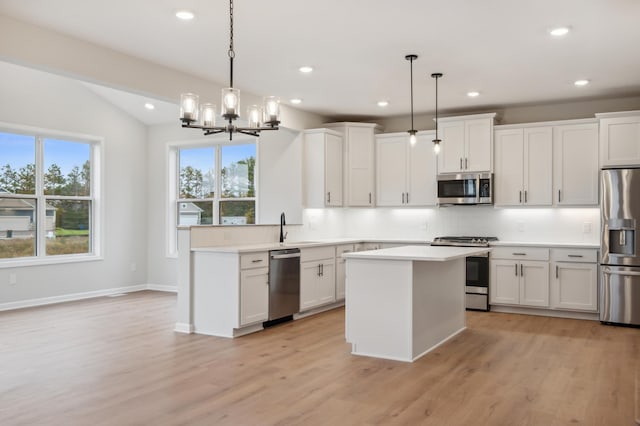 kitchen featuring appliances with stainless steel finishes, tasteful backsplash, recessed lighting, a sink, and light wood finished floors