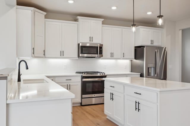 kitchen with appliances with stainless steel finishes, a sink, recessed lighting, decorative backsplash, and white cabinets