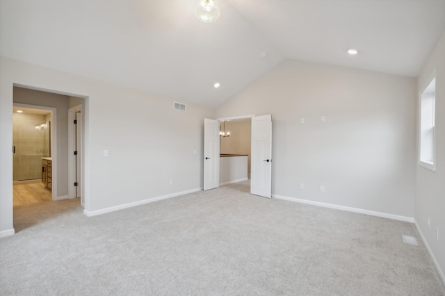 unfurnished bedroom featuring light carpet, lofted ceiling, baseboards, and recessed lighting