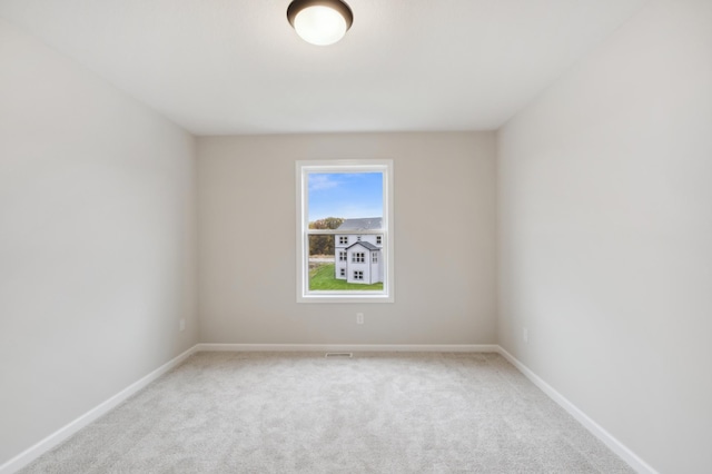 spare room featuring carpet floors and baseboards