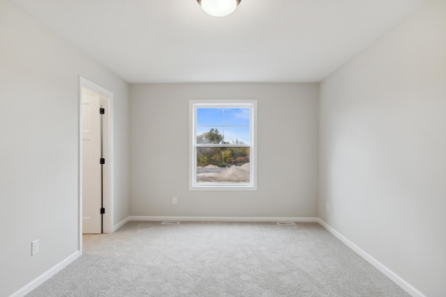 carpeted spare room featuring baseboards