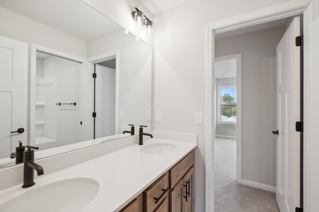 full bath with double vanity and baseboards