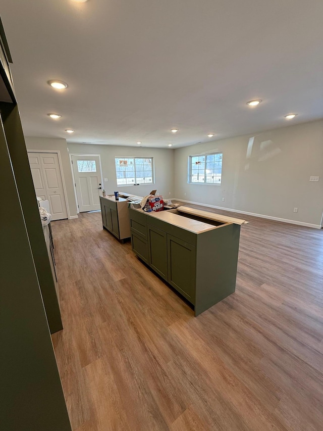 6809 Hamilton Park NW Unit 12, Bemidji, MN 56601 - kitchen with wood finished floors, a kitchen island, recessed lighting, baseboards, and green cabinetry