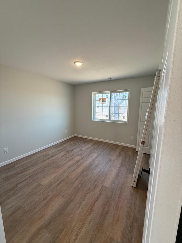6809 Hamilton Park NW Unit 12, Bemidji, MN 56601 - spare room featuring dark wood-type flooring and baseboards