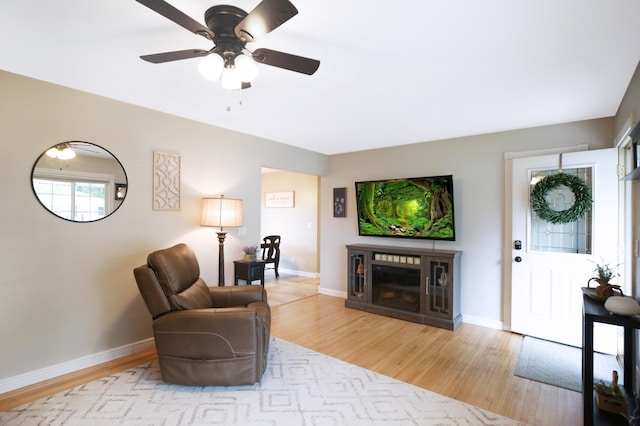 726 17th St NE, Owatonna, MN 55060 - living room featuring light wood-style flooring, a ceiling fan, baseboards, and a fireplace