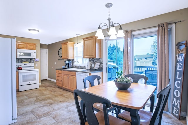726 17th St NE, Owatonna, MN 55060 - dining area featuring a chandelier, baseboards, and stone finish floors