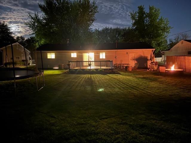 726 17th St NE, Owatonna, MN 55060 - view of green lawn featuring a trampoline, an outdoor fire pit, and a deck