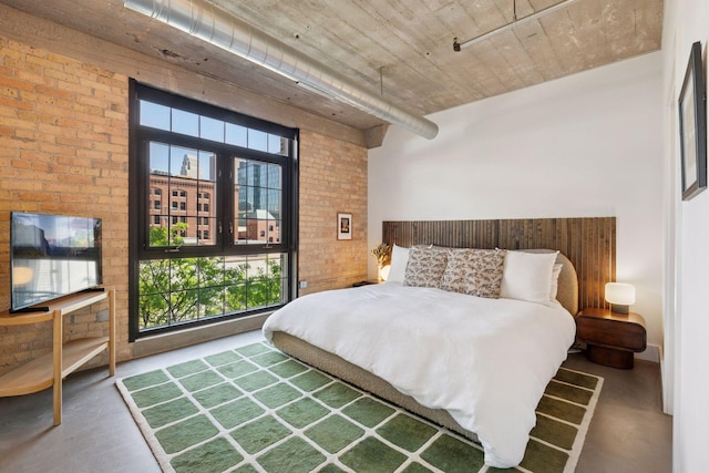 bedroom with concrete floors and brick wall