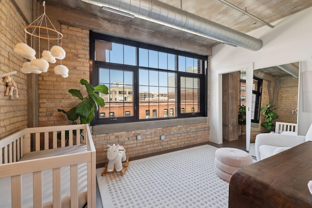 bedroom featuring brick wall and carpet flooring