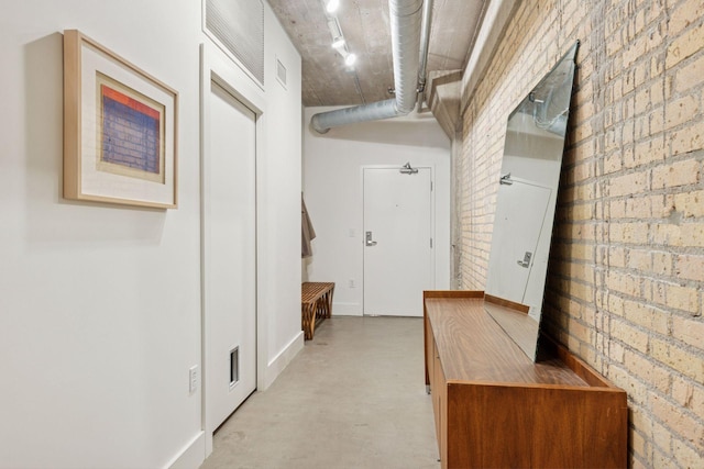 corridor featuring brick wall