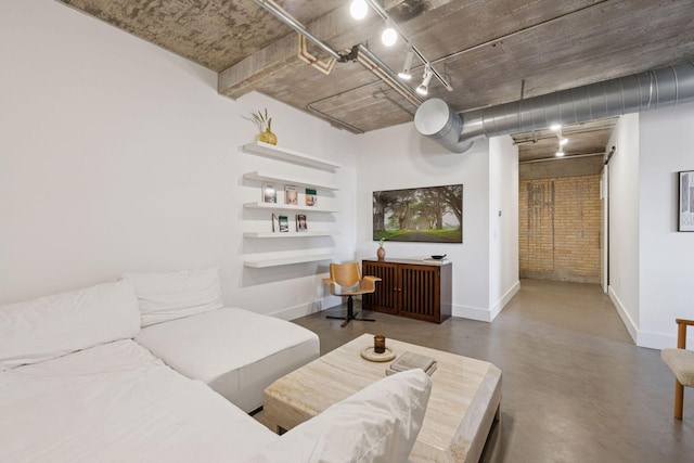 living area featuring baseboards and track lighting