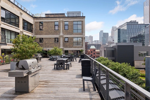 wooden terrace with area for grilling and outdoor dining area