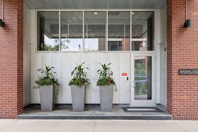 view of exterior entry featuring brick siding