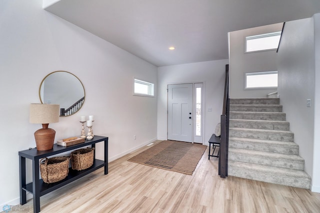 foyer entrance featuring stairs, wood finished floors, baseboards, and recessed lighting