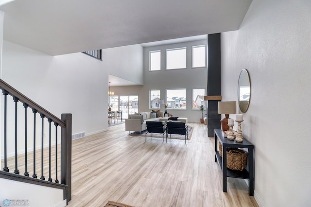 entryway with wood finished floors, baseboards, stairway, and a towering ceiling