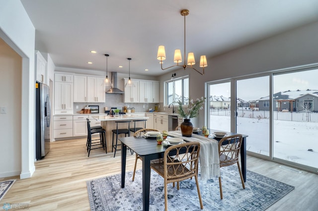 dining area featuring light wood-style flooring, recessed lighting, a chandelier, and baseboards