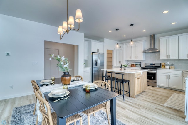 dining area with light wood-style floors, recessed lighting, a chandelier, and baseboards