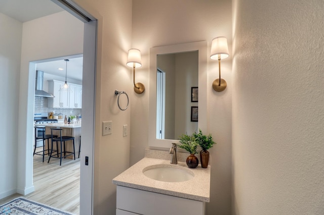 bathroom featuring tasteful backsplash, wood finished floors, and vanity