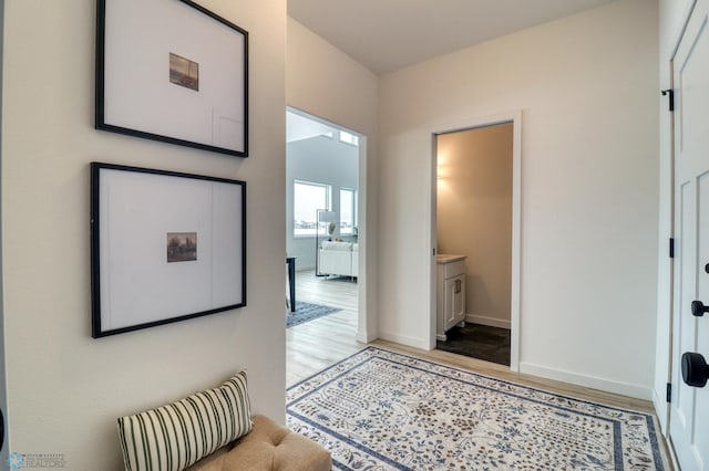 hall featuring light wood finished floors and baseboards