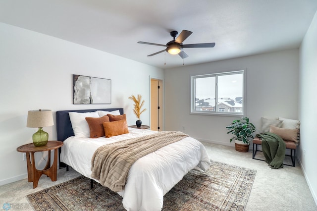 bedroom with light colored carpet, baseboards, and a ceiling fan