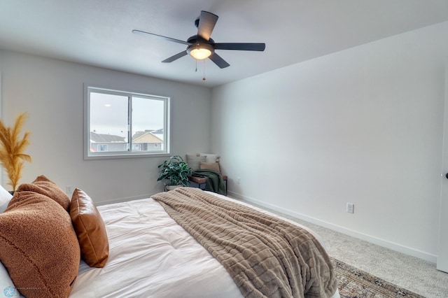 carpeted bedroom featuring baseboards and a ceiling fan
