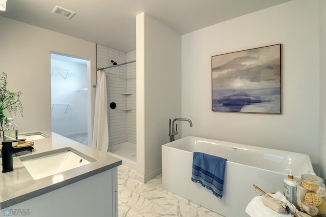 full bathroom with marble look tiles, a shower stall, a soaking tub, vanity, and a spacious closet