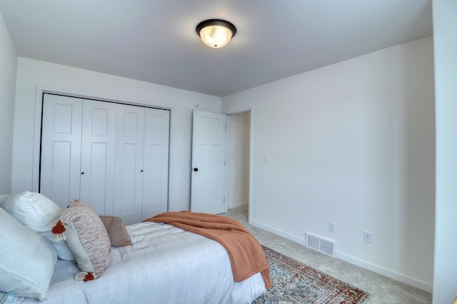 bedroom with light carpet, a closet, and baseboards