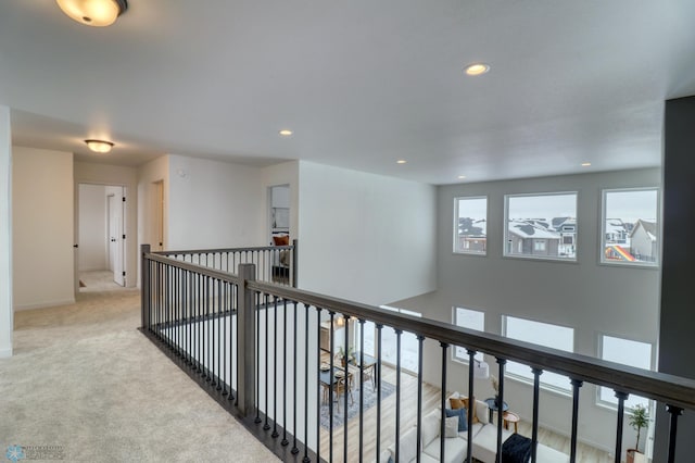 hall with recessed lighting, an upstairs landing, baseboards, and carpet floors