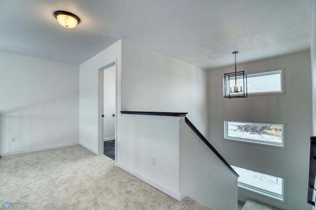 foyer with a chandelier, carpet, and baseboards