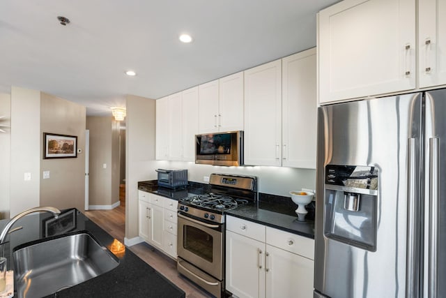 kitchen featuring stainless steel appliances, a sink, white cabinetry, and recessed lighting